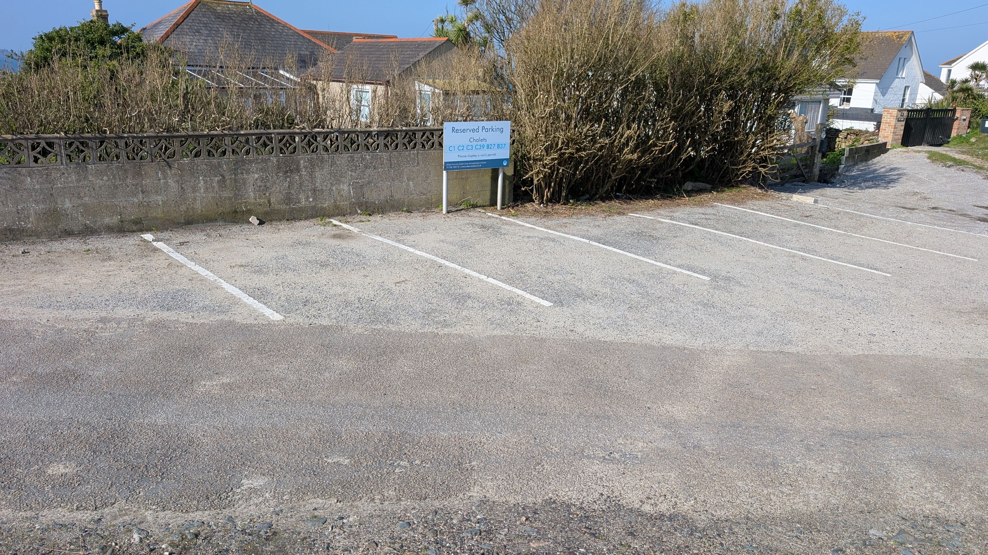 A parking area with a sign indicating reserved parking for specific addresses.