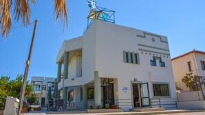 Un edificio moderno con un'insegna che riporta la scritta “ILIAS APARTMENTS”.