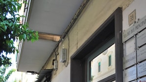 A narrow street with buildings on either side, a visible number '39' sign, and a window with a circular object inside. - Suite 39 Guest House (Salerno)