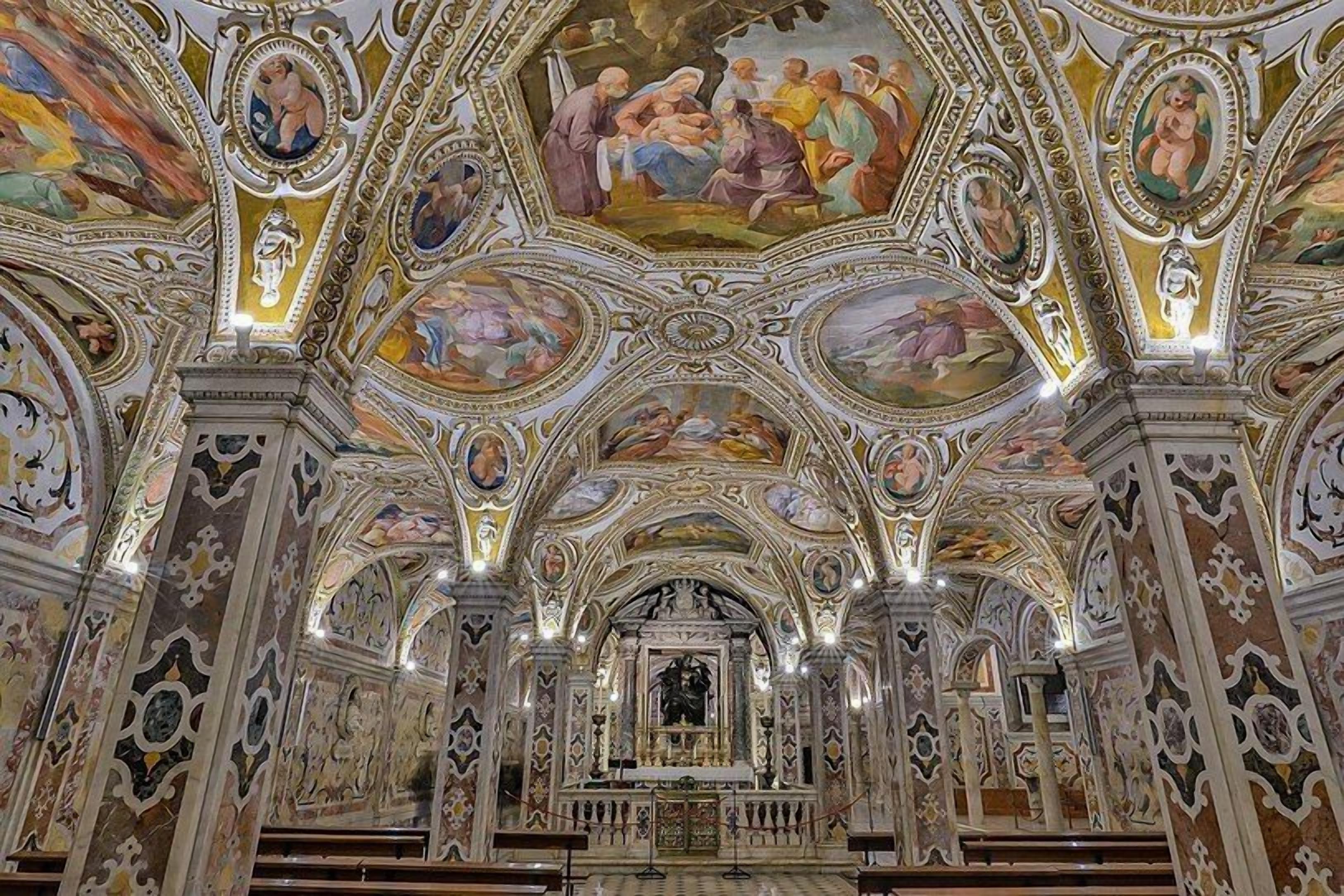An ornate church interior with detailed frescoes and a central altar.