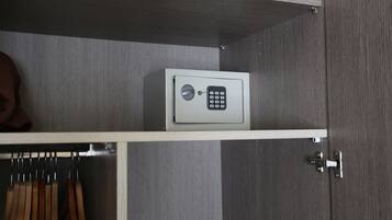 A secure safe on a shelf in a room with a wooden floor and a metal door.