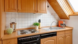 Eine Küche mit Holzschränken, einem Herd, einer Spüle und einem Toaster.