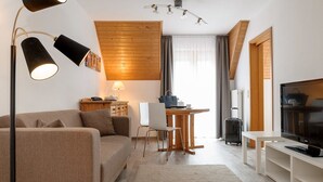 Ein modernes Wohnzimmer mit einer Couch, einem Esstisch und einem Fernseher.