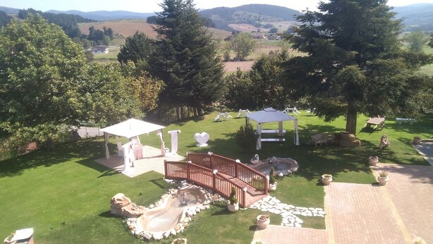 A landscaped garden with a gazebo, seating area, and a small pond. - Grandinetti Hotel (Parenti)