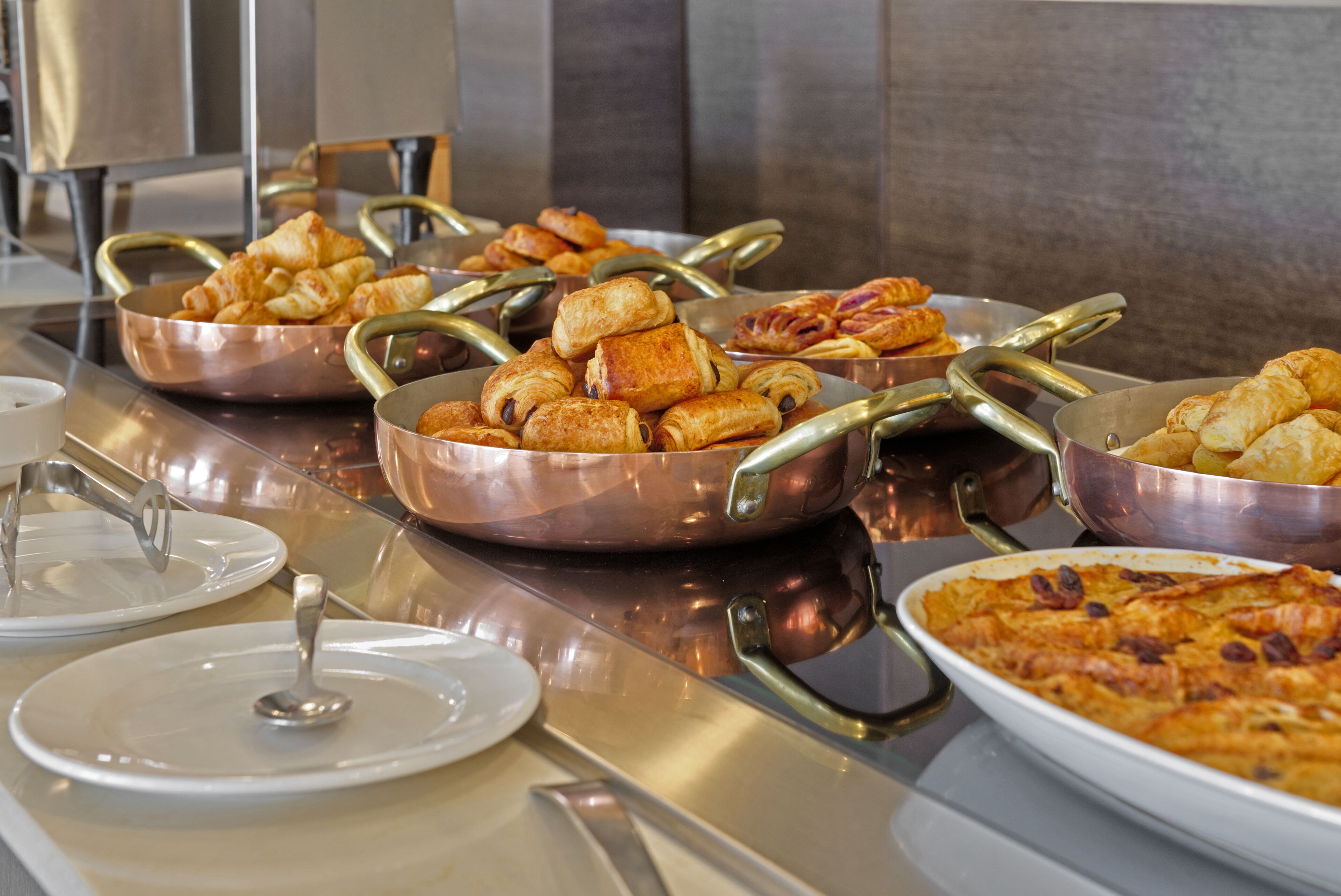 A buffet with various baked goods and a casserole dish.