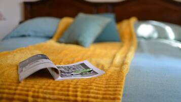 A bed with a yellow blanket, a magazine, and a pen on it.