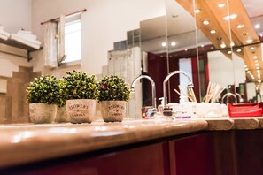 Uma bancada de cozinha com três vasos de plantas identificados como 