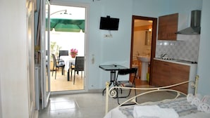 Un dormitorio con cama, escritorio, silla y televisor.