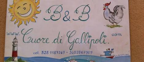 A colorful business card for 'B&B Evere di Gallipoli' with contact numbers, a lighthouse illustration, a rooster, and a boat with fish.