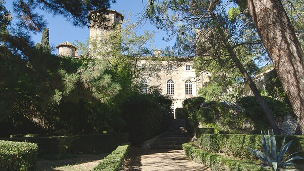 A historic building with a central tower, surrounded by well-maintained gardens and a clear pathway leading to the entrance. - Chateau d'Agel (Agel)