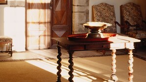 A room with a wooden door, a chandelier, a table, and chairs. - Chateau d'Agel (Agel)
