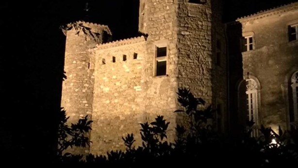 A stone castle with a prominent tower, surrounded by foliage. - Chateau d'Agel (Agel)