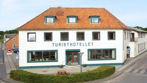 A two-story building with the sign "TURISTHOTELLET" on the front.