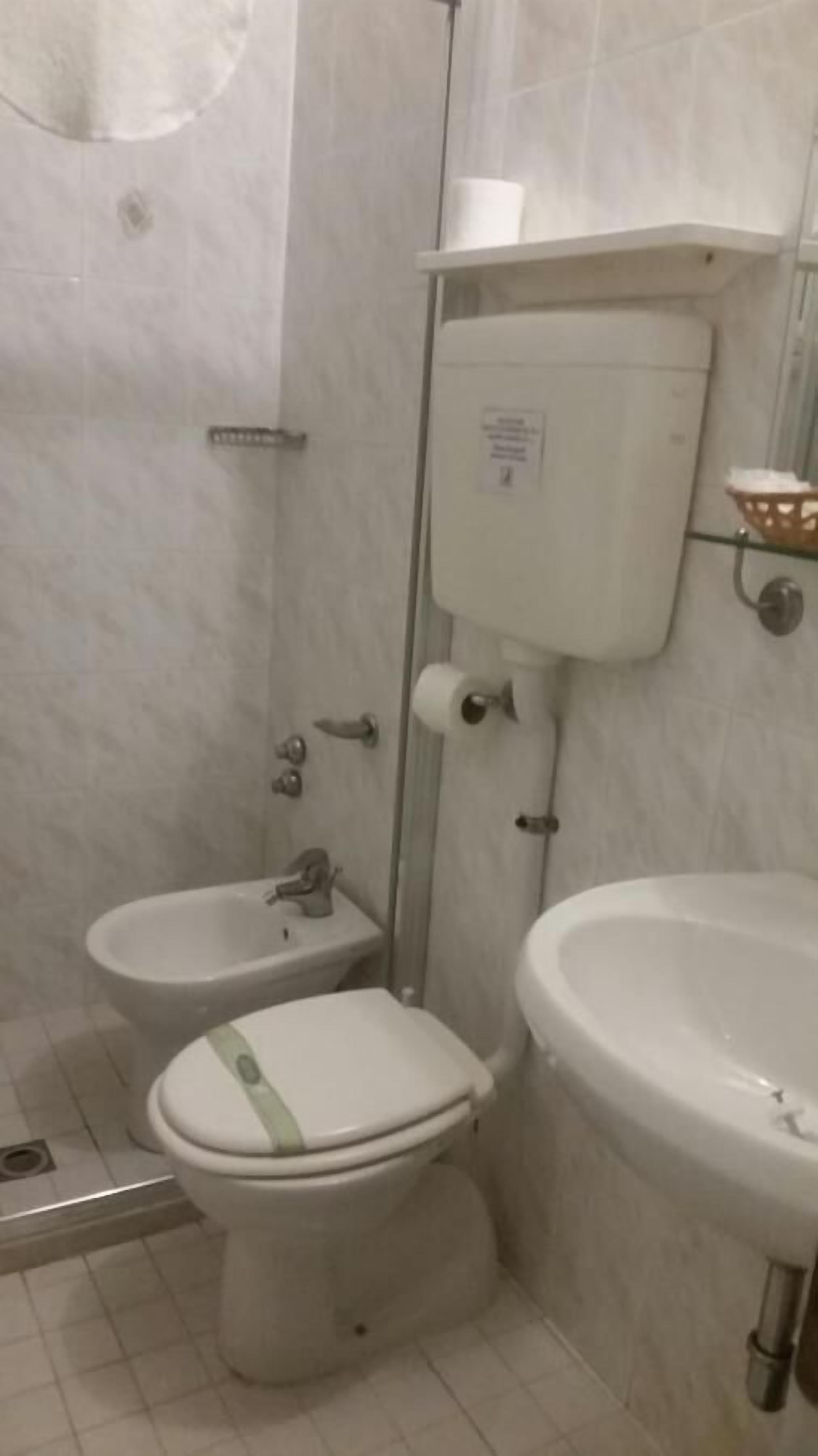 A bathroom with a toilet, bidet, and sink.