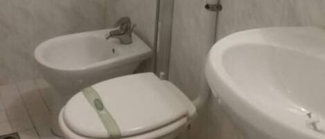 A bathroom with a toilet, bidet, and sink.