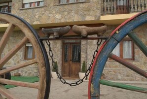Un edificio de piedra con puerta de madera y un balcón con barandillas metálicas.