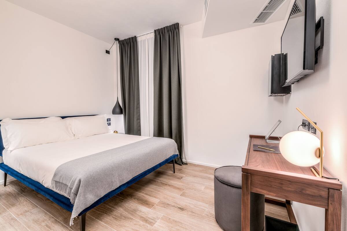 Una camera da letto moderna con un letto, una scrivania e una sedia.