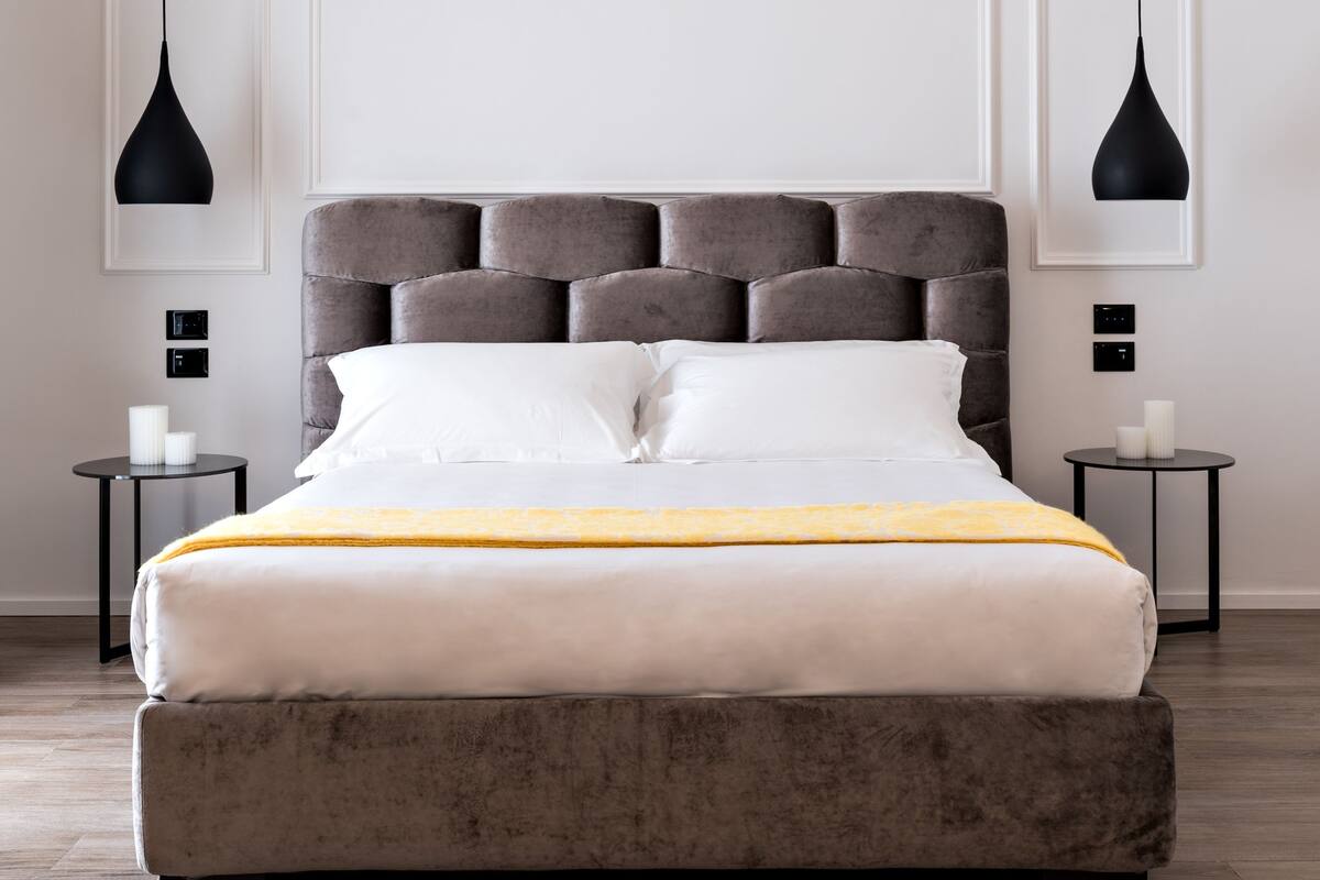 Una camera da letto moderna con un letto grande, due comodini e lampade a sospensione.