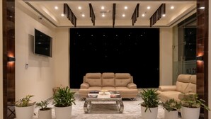 Una sala de estar moderna con un sofá color beige, una mesa de centro y plantas en macetas.