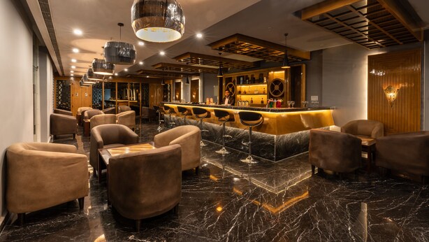 A modern bar area with seating and a bar counter. - Cygnett Lite (Alwar)