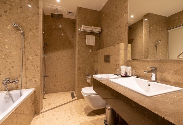 A modern bathroom with a walk-in shower, a bathtub, a toilet, and a vanity with a sink.