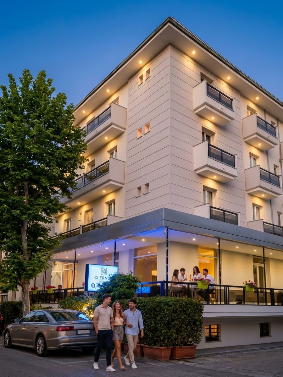 A multi-story hotel with a modern design, featuring balconies on each floor, a covered entrance area, and a visible restaurant sign.