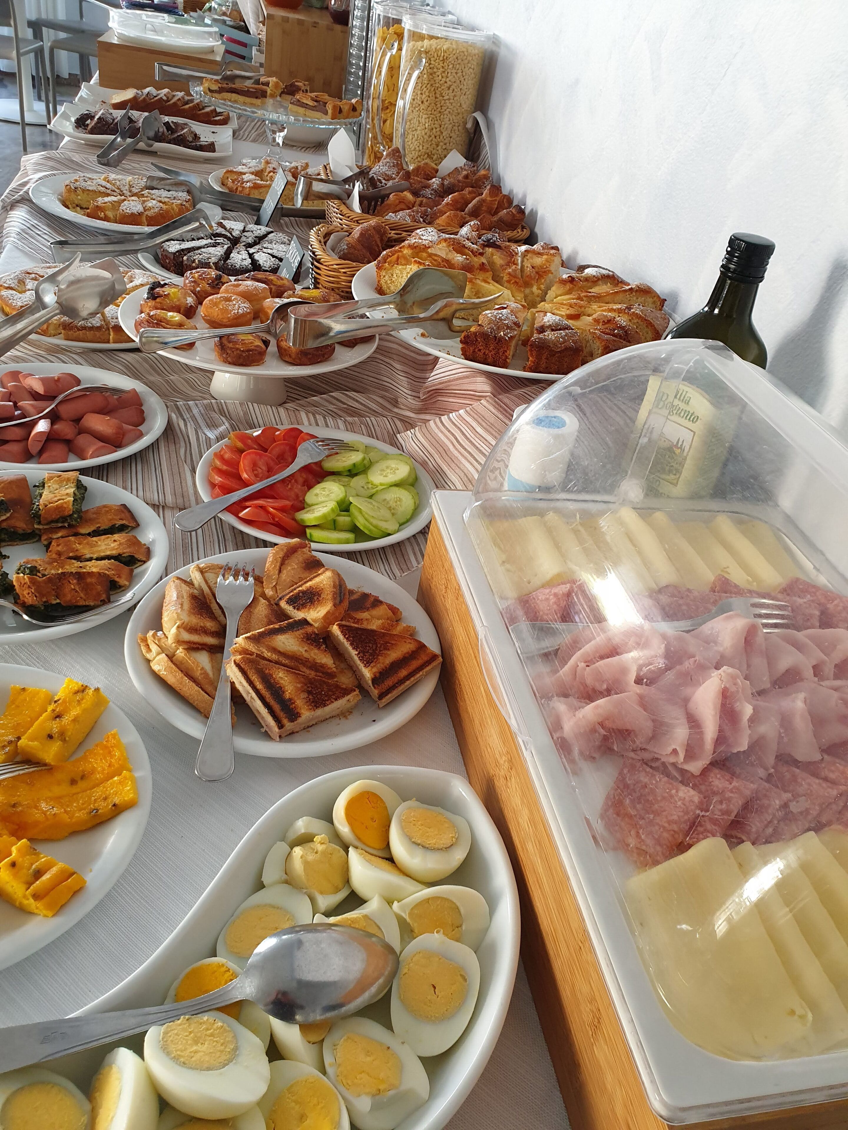 A buffet with various food items including meats, cheeses, eggs, and vegetables.