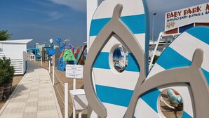 A beachside walkway with a sign listing nearby locations and a Baby Park sign. - Beach Hotel Clerice (Rimini)