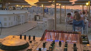 A beachside bar area with a DJ booth, umbrellas, and outdoor seating. - Beach Hotel Clerice (Rimini)