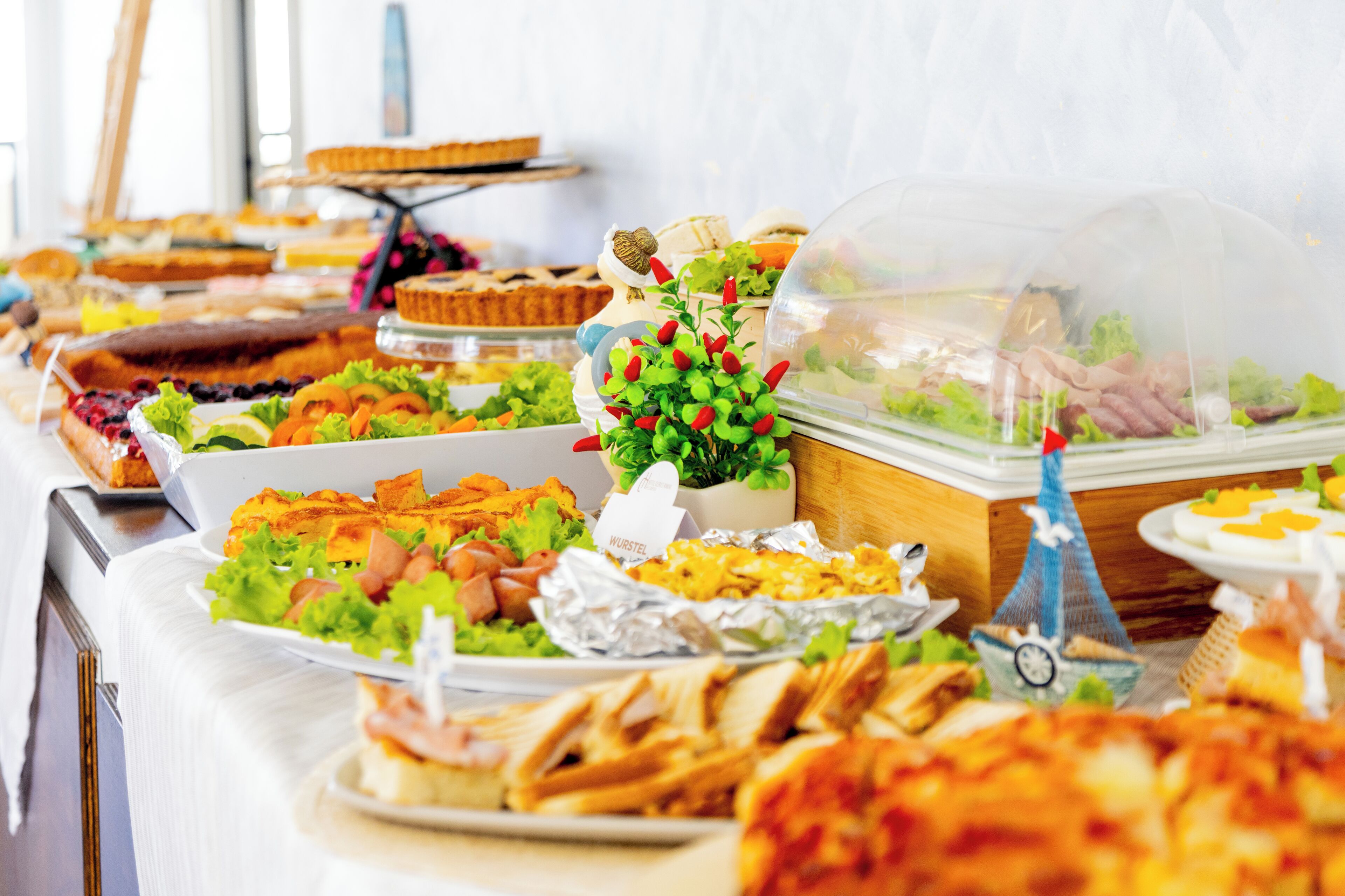 A buffet with various food items, including salads, sandwiches, and desserts.
