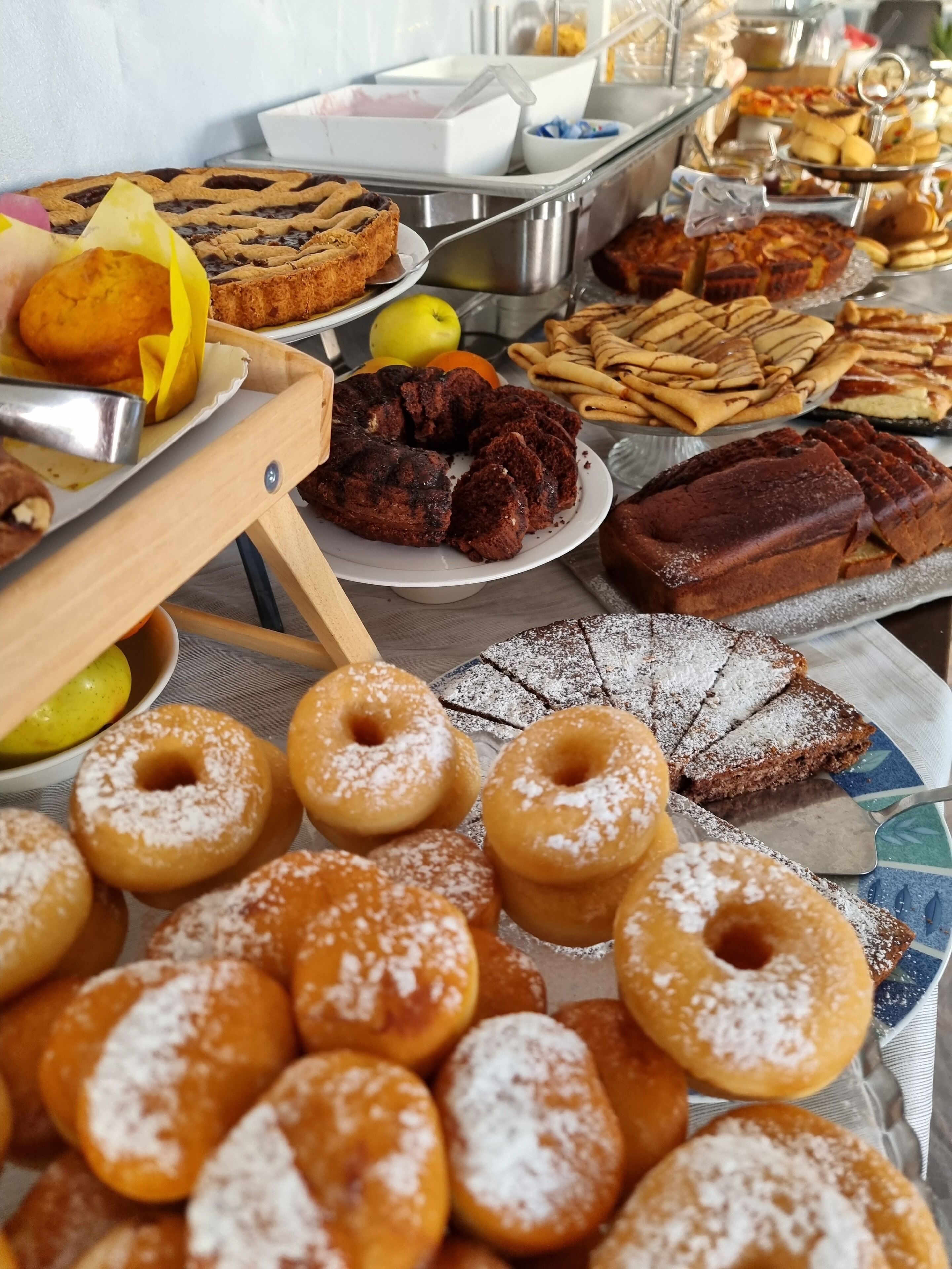 Ein Buffet mit verschiedenen Desserts, darunter Kuchen, Donuts und Gebäck.