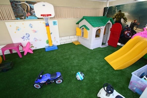A children's play area with a basketball hoop, a small house, a slide, and a toy car. - Beach Hotel Clerice (Rimini)