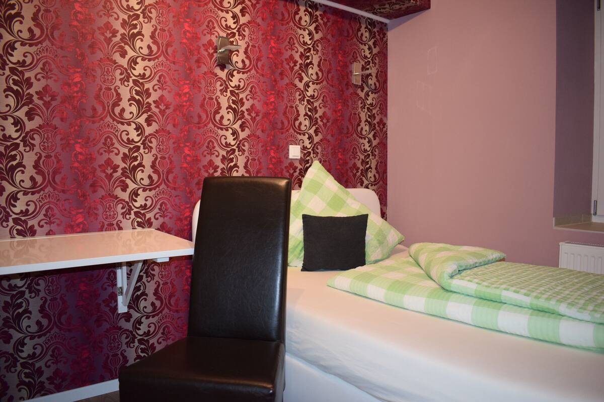 Una habitaci ón con una cama, una silla y un escritorio.