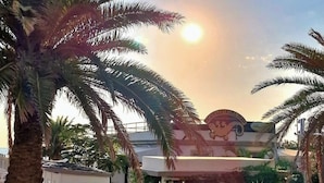 A building with a sign that reads "COSTA DEL MAR" and palm trees in the foreground. - Hotel Kim (Rimini)