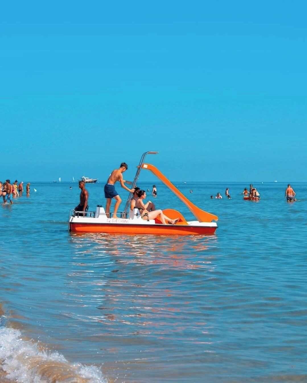 Un bateau avec des personnes à bord, sur une étendue d’eau.