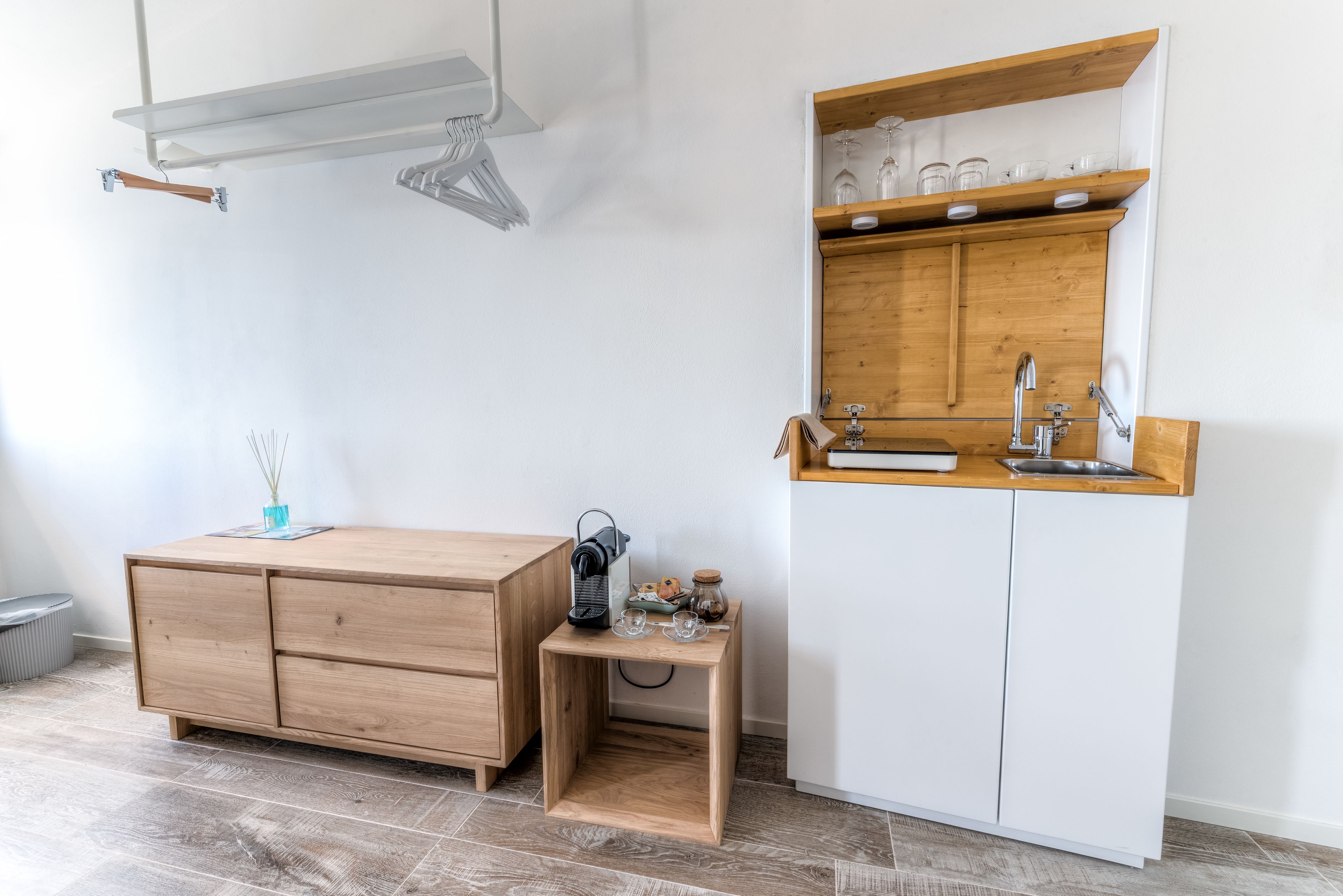 A compact kitchen with a wooden cabinet, a small wooden table, and a built-in sink.
