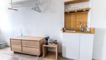 A compact kitchen with a wooden cabinet, a small wooden table, and a built-in sink.