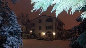 A building with a symmetrical facade, a central entrance with steps, and a driveway leading to a parked car. - Agriturismo Corte Trincerone (Mantua)
