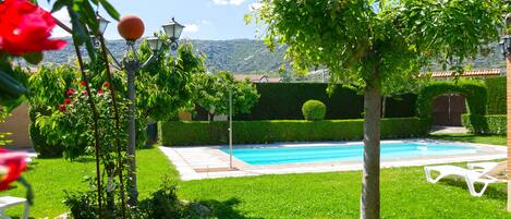 Una piscina al aire libre de temporada, sombrillas