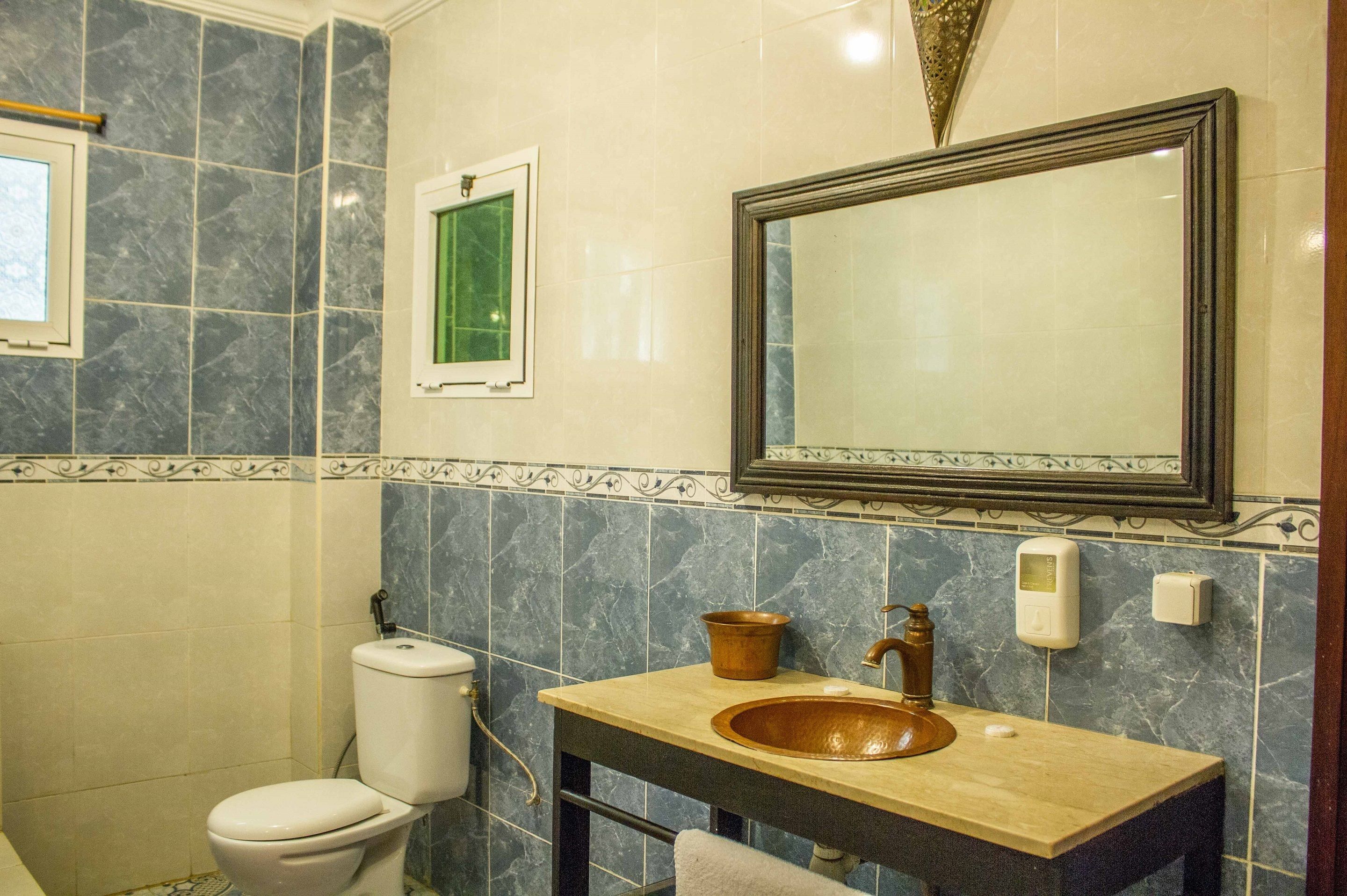Un bagno con il water, un lavandino e uno specchio.