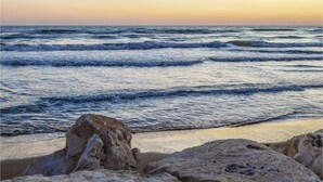 A beach with waves and rocks.