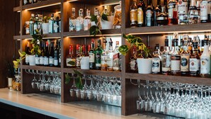 A bar area with shelves stocked with various liquor bottles and wine glasses. - Rydges Pit Lane Hotel (Tailem Bend)