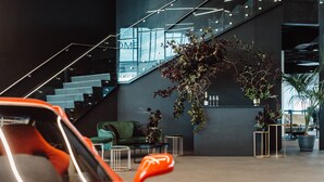 A modern interior with a staircase, a green sofa, and a potted plant. - Rydges Pit Lane Hotel (Tailem Bend)