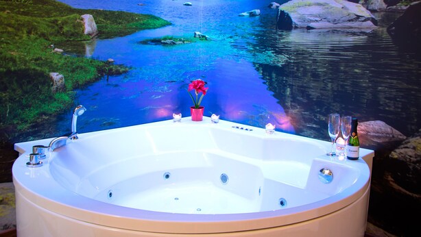 A large bathtub with a view of a lake and mountains in the background. - Casa Rural El Cuco (Solosancho)