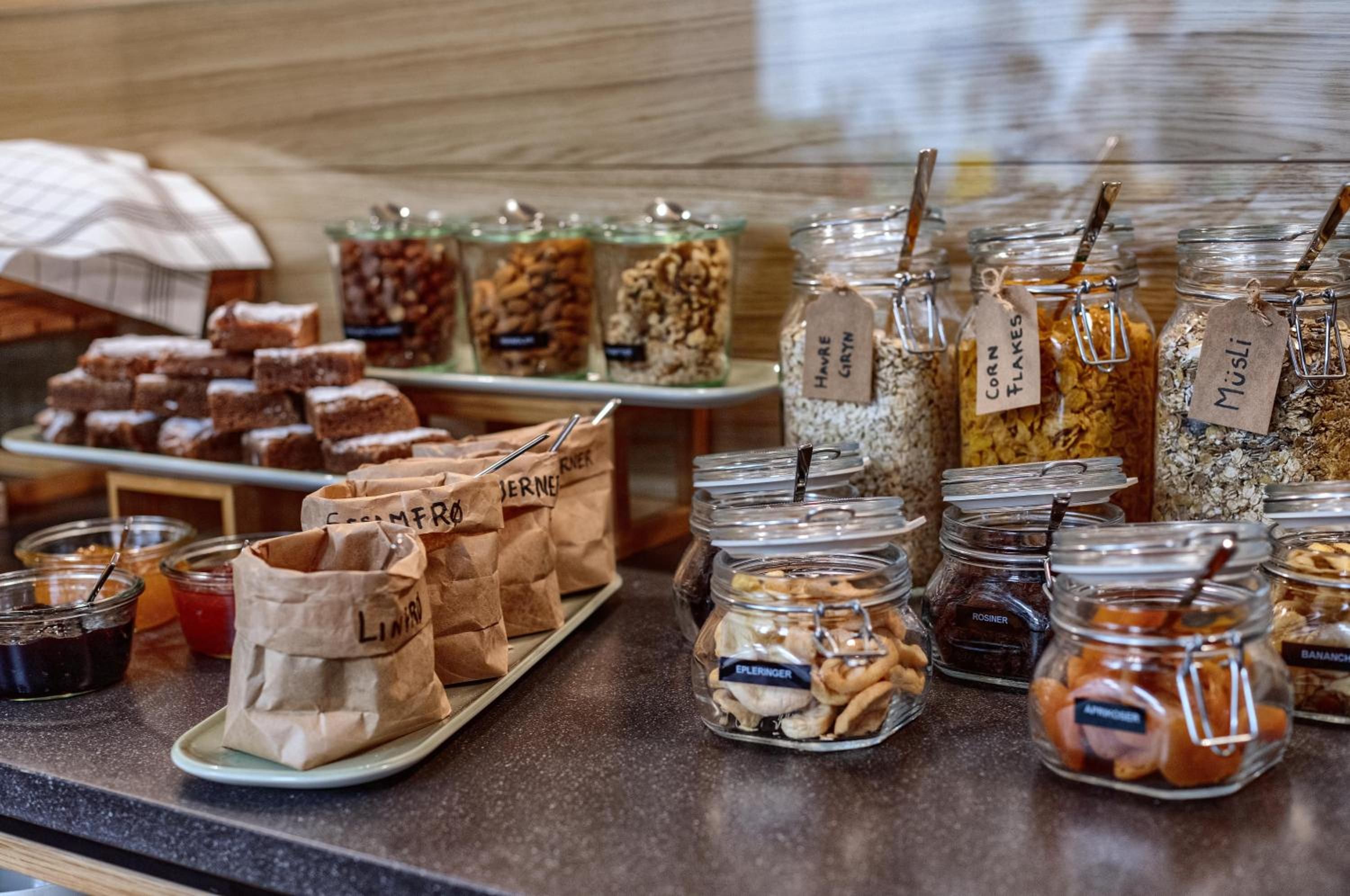A variety of food items including jars of honey, nuts, and dried fruits, as well as paper bags labeled with names like 'LINARI' and 'HAVRE'.