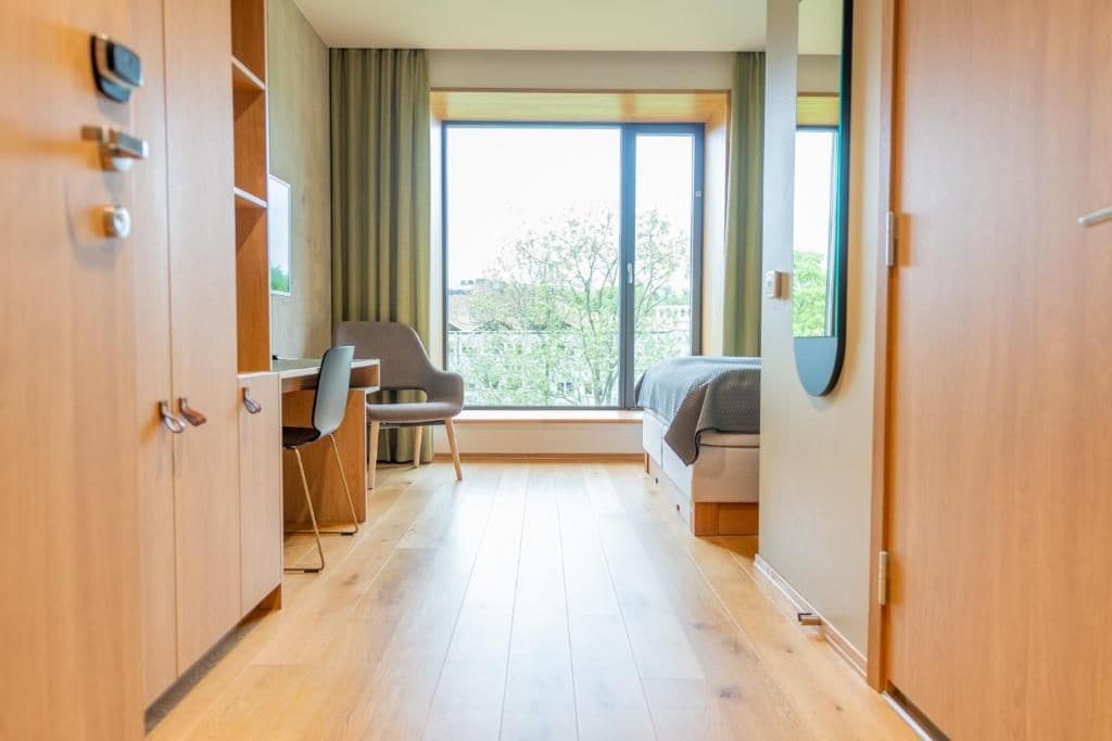 Ett hotellrum med ett skrivbord, en stol och en säng.