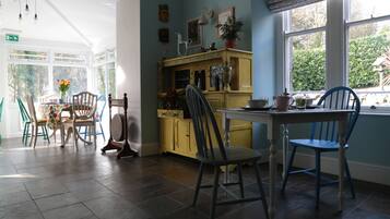 A kitchen with a dining table, chairs, and a window with a view of greenery outside.