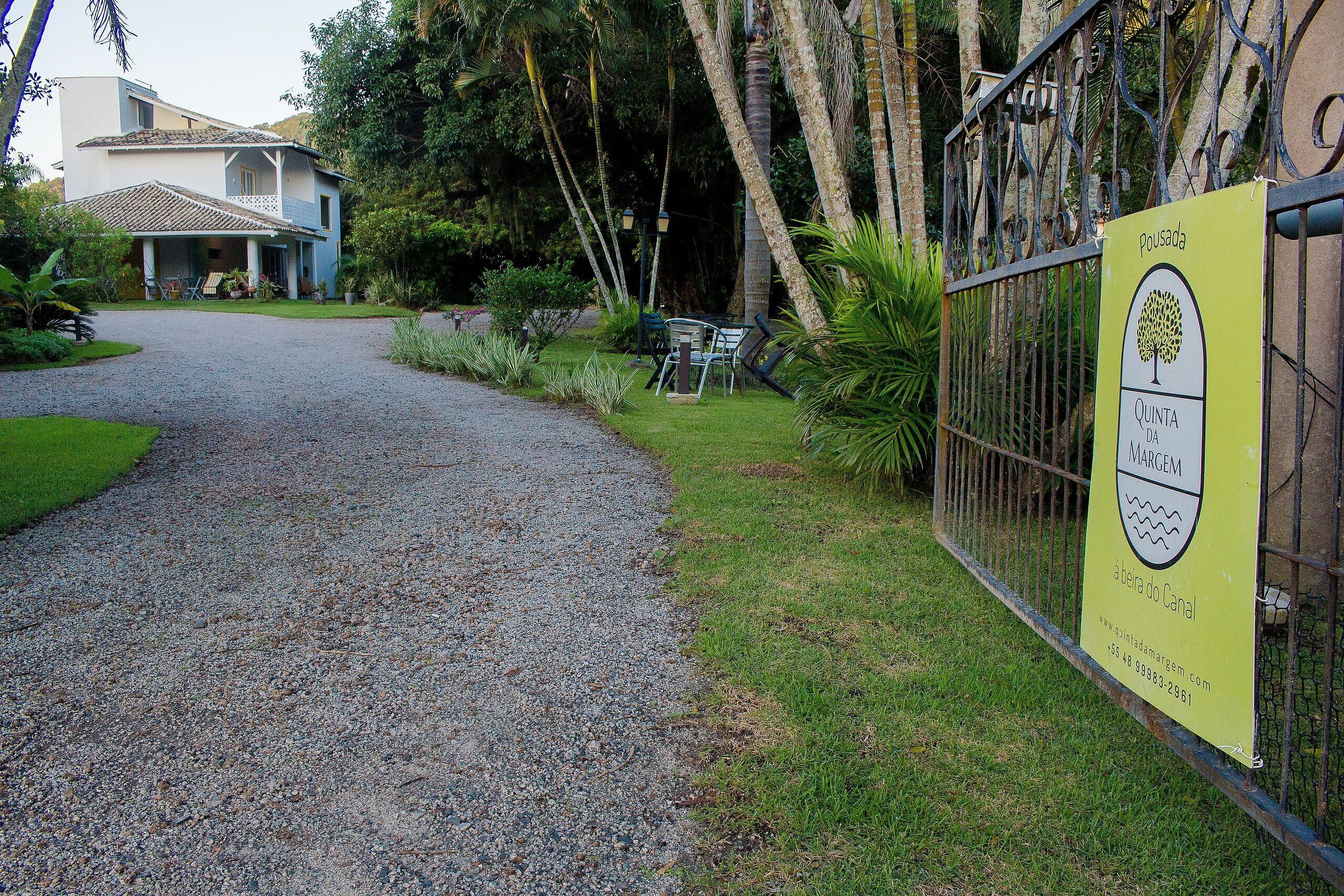 A house with a gravel driveway and a fenced garden area.
