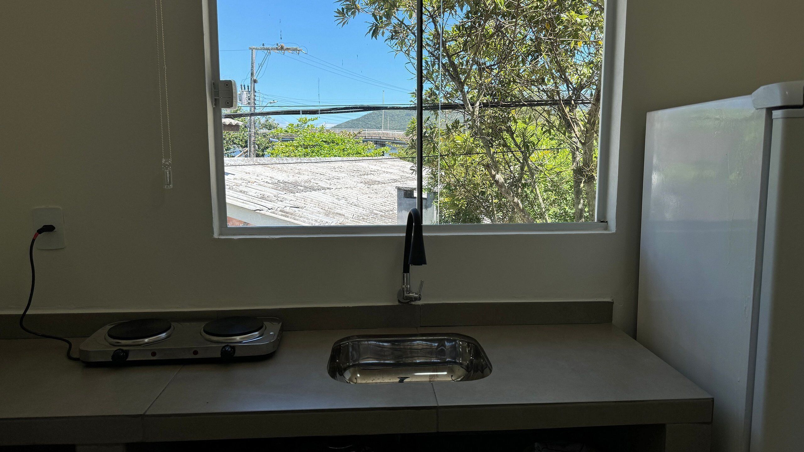 Una cocina con ventana, un lavamanos y una estufa.