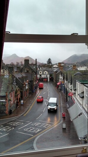 A street view with buildings, a road, and mountains in the background. - Swiss Court (Keswick)